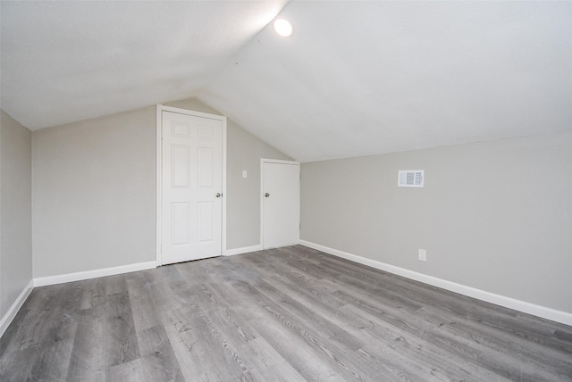 bonus room featuring vaulted ceiling and hardwood / wood-style floors