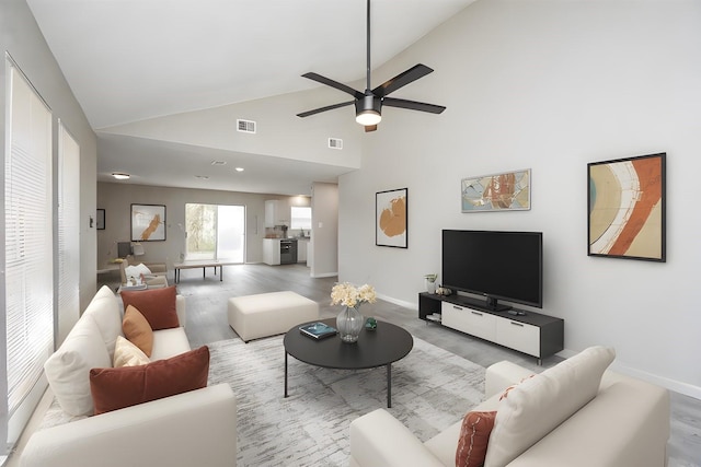 living room with hardwood / wood-style flooring, ceiling fan, and high vaulted ceiling