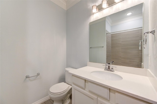 bathroom featuring vanity, toilet, crown molding, and a tile shower