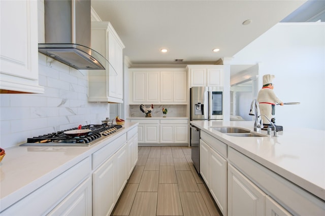 kitchen featuring white cabinetry, sink, wall chimney exhaust hood, and stainless steel appliances