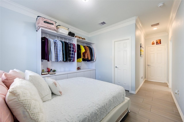 bedroom with light wood-type flooring, a closet, and ornamental molding