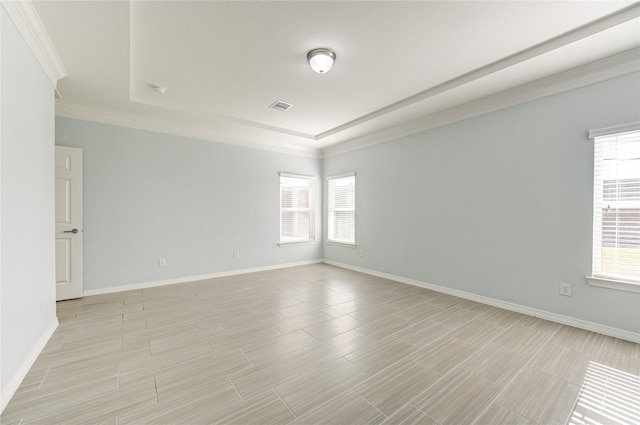 unfurnished room with a tray ceiling and ornamental molding