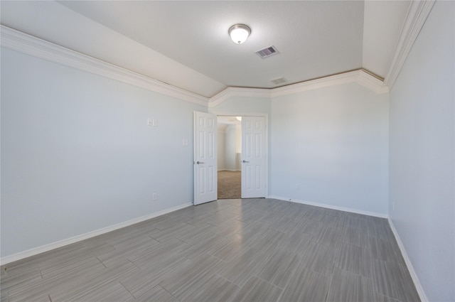 spare room with crown molding, hardwood / wood-style floors, and lofted ceiling