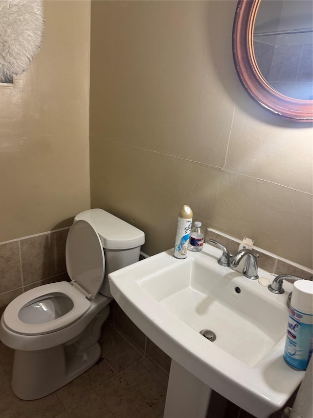 bathroom with toilet, tile patterned floors, and sink