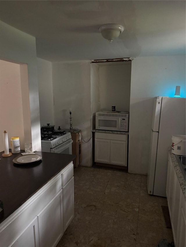 kitchen featuring white cabinets and white appliances