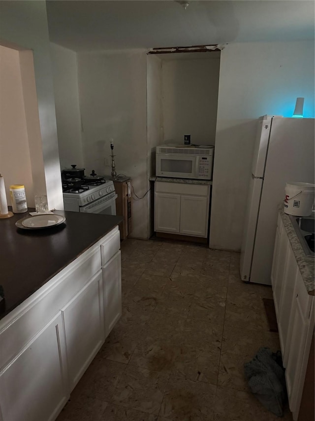 kitchen with white cabinets and white appliances