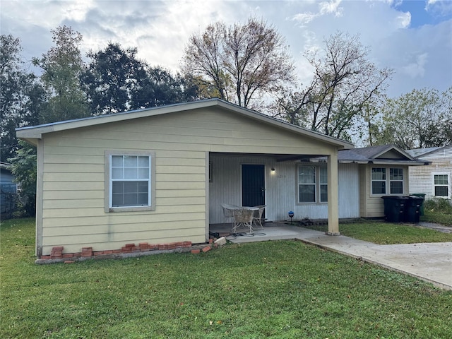 view of front of house with a front yard and a patio area