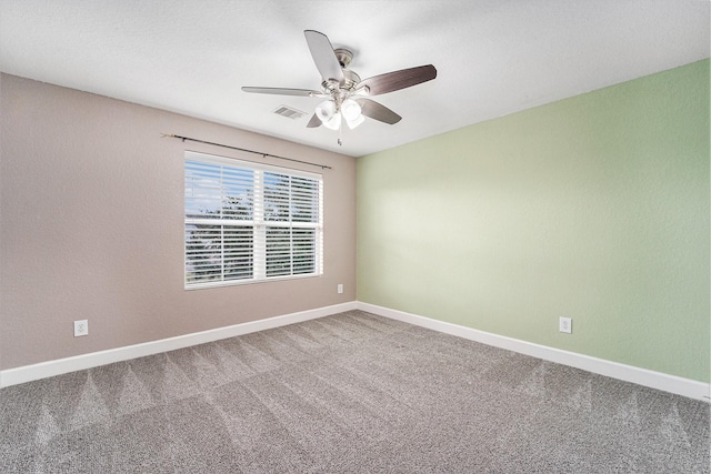 unfurnished room with ceiling fan and carpet