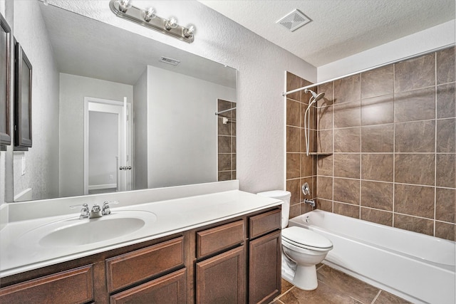 full bathroom with tiled shower / bath combo, toilet, a textured ceiling, and vanity