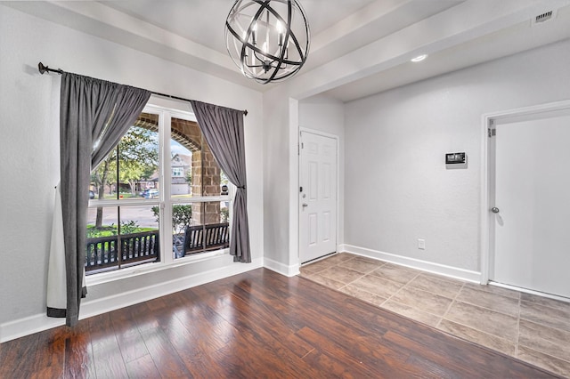 foyer entrance featuring hardwood / wood-style flooring and a notable chandelier