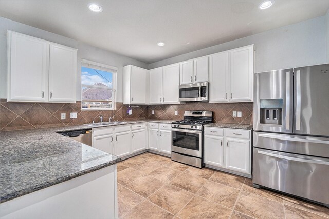 kitchen featuring sink, white cabinets, dark stone counters, and stainless steel appliances