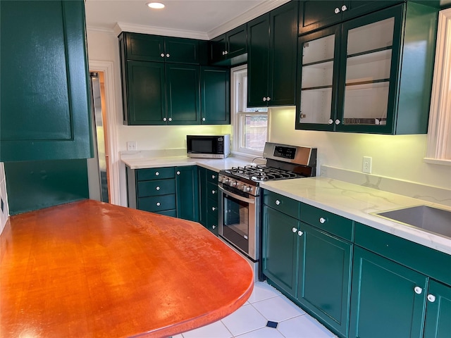 kitchen featuring light stone counters, ornamental molding, stainless steel appliances, sink, and light tile patterned floors