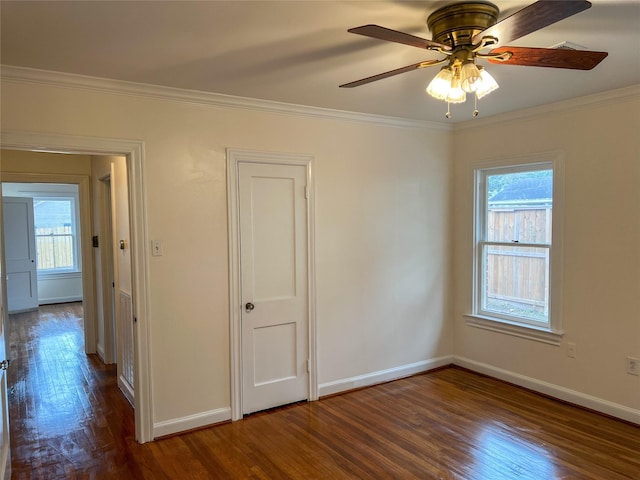 unfurnished room featuring ceiling fan, a healthy amount of sunlight, dark hardwood / wood-style floors, and ornamental molding