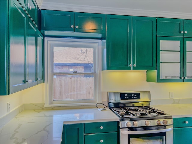 kitchen with light stone countertops, green cabinetry, ornamental molding, and stainless steel gas range