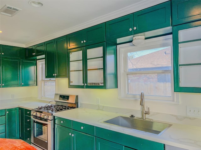 kitchen featuring light stone countertops, crown molding, sink, green cabinetry, and stainless steel range with gas stovetop