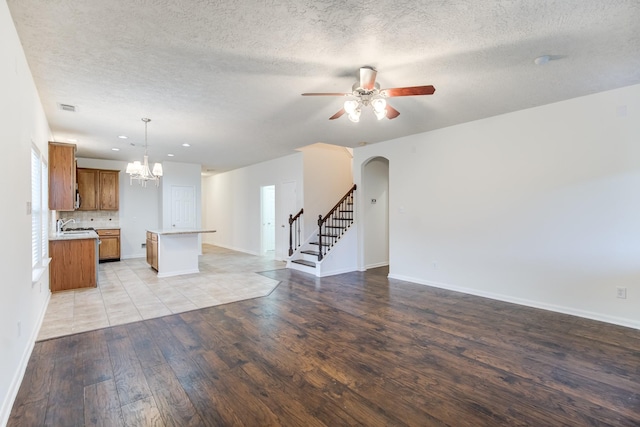 unfurnished living room featuring a textured ceiling, light hardwood / wood-style floors, and sink