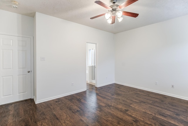 spare room with ceiling fan, dark wood-type flooring, and a textured ceiling