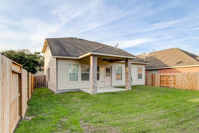 back of house featuring a lawn, ceiling fan, and a patio