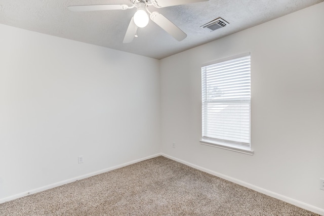 spare room with ceiling fan, carpet, and a textured ceiling