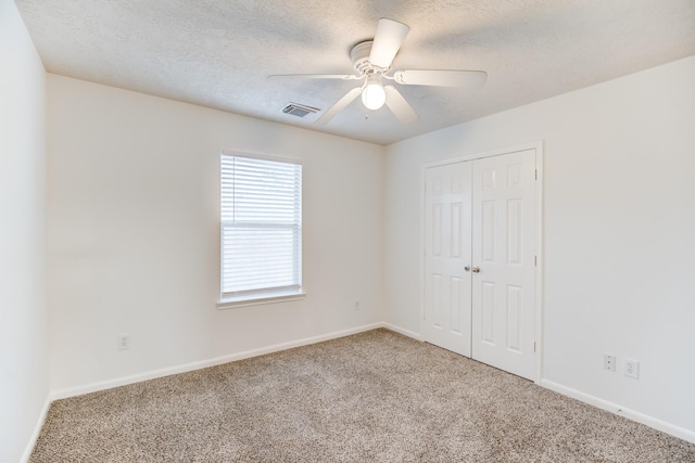 empty room with carpet, a textured ceiling, and ceiling fan