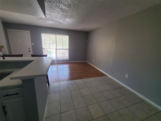 interior space with a textured ceiling and light hardwood / wood-style flooring