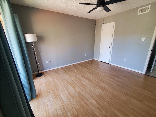 empty room with wood-type flooring, a textured ceiling, and ceiling fan