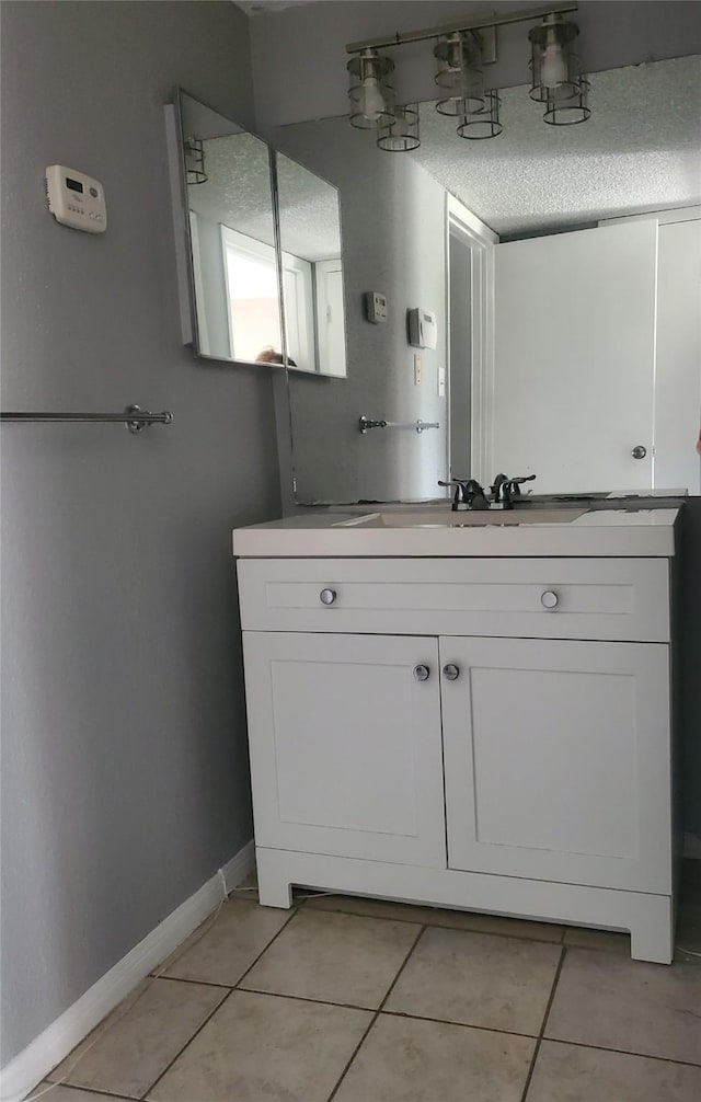 bathroom with a textured ceiling, vanity, and tile patterned floors