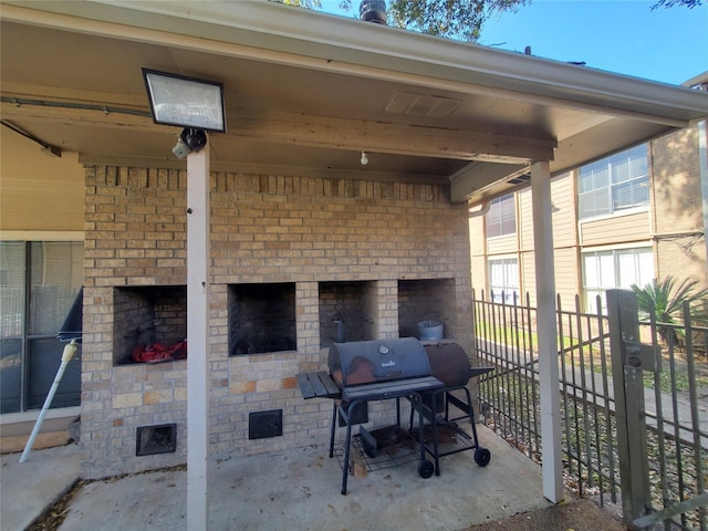 view of patio with a grill and an outdoor fireplace