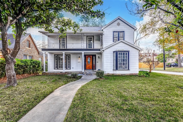 view of front of house with a front yard, a porch, and a balcony