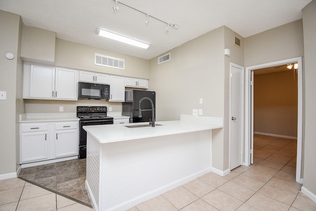 kitchen with a textured ceiling, sink, black appliances, light tile patterned floors, and white cabinets