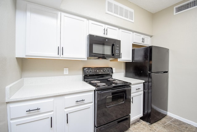 kitchen featuring black appliances, light tile patterned flooring, and white cabinetry