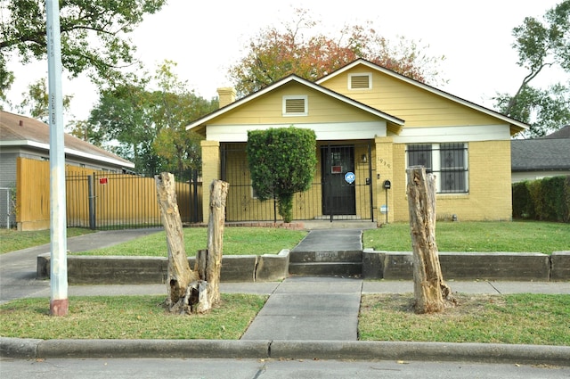 bungalow-style home featuring a front lawn