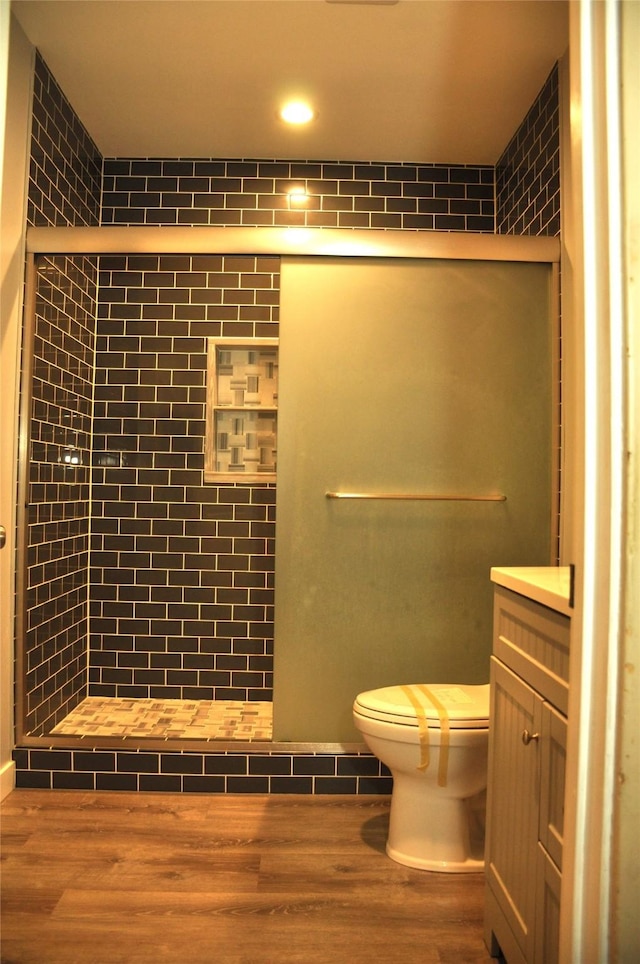 bathroom with walk in shower, wood-type flooring, toilet, and vanity