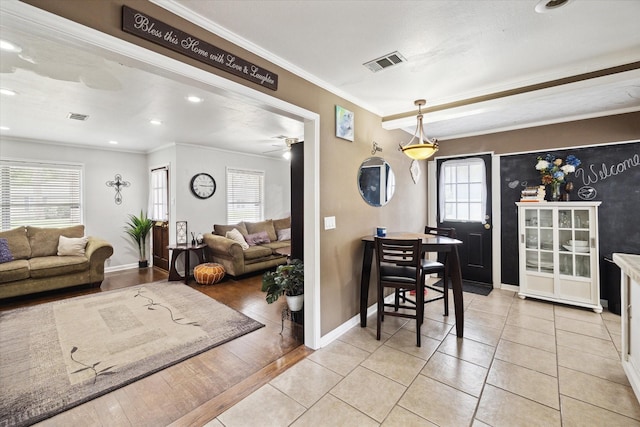 dining room with ceiling fan, light tile patterned floors, and crown molding