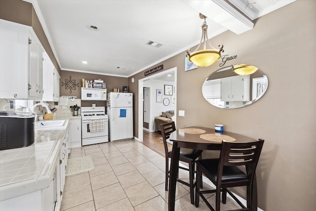 kitchen with white cabinetry, tile counters, sink, pendant lighting, and white appliances