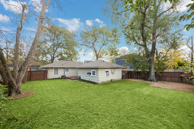 rear view of house with a yard and cooling unit