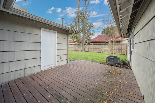 wooden deck featuring cooling unit and a lawn