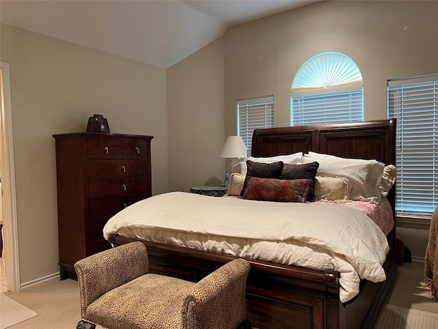 bedroom featuring light colored carpet and lofted ceiling