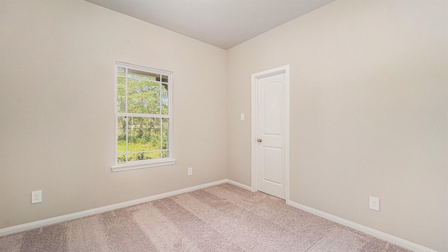 spare room featuring light colored carpet