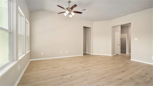 empty room with ceiling fan, vaulted ceiling, and light hardwood / wood-style flooring