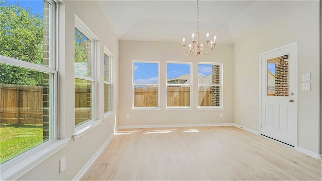 unfurnished sunroom with a wealth of natural light, lofted ceiling, and a notable chandelier