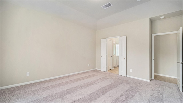 unfurnished bedroom with lofted ceiling and light carpet