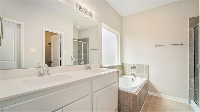 bathroom featuring hardwood / wood-style floors, vanity, and independent shower and bath