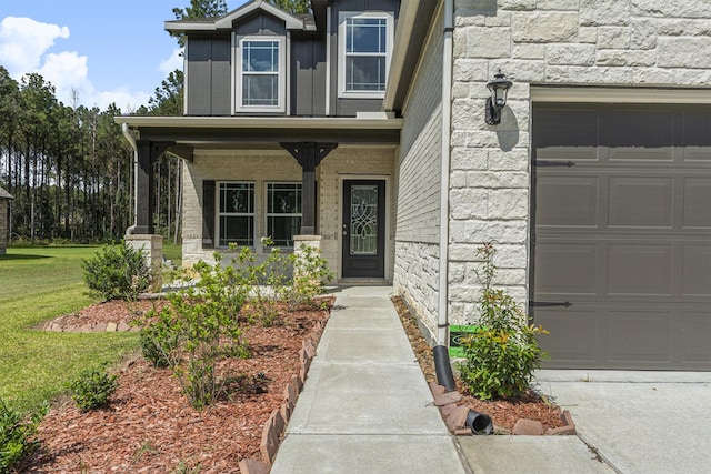 entrance to property featuring covered porch and a yard