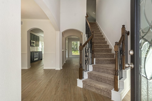 foyer with hardwood / wood-style floors and crown molding