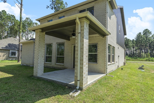 rear view of property featuring a yard, ceiling fan, and a patio area