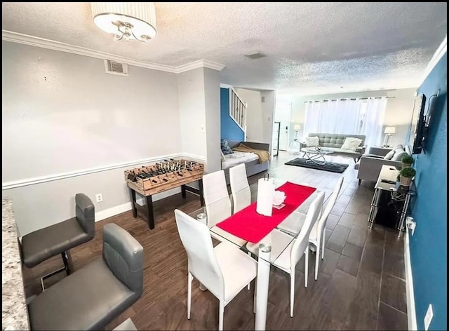 dining space with dark hardwood / wood-style flooring, a textured ceiling, and ornamental molding