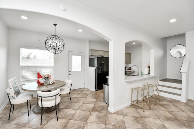 dining room featuring sink and a chandelier