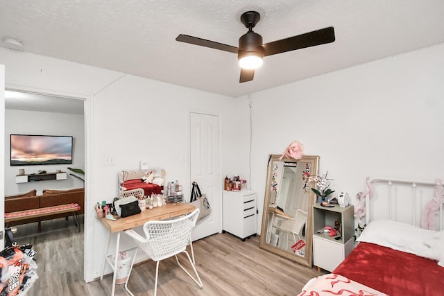 bedroom featuring a textured ceiling, light hardwood / wood-style floors, and ceiling fan