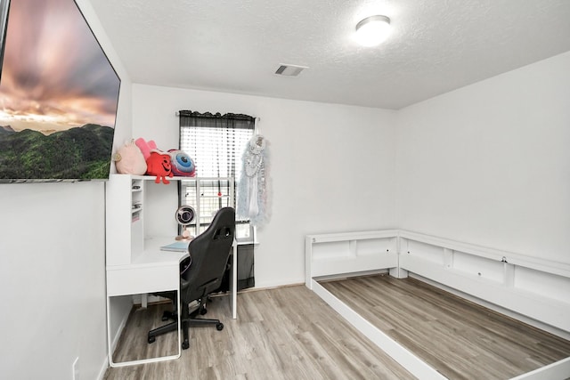 office featuring a textured ceiling and light hardwood / wood-style floors